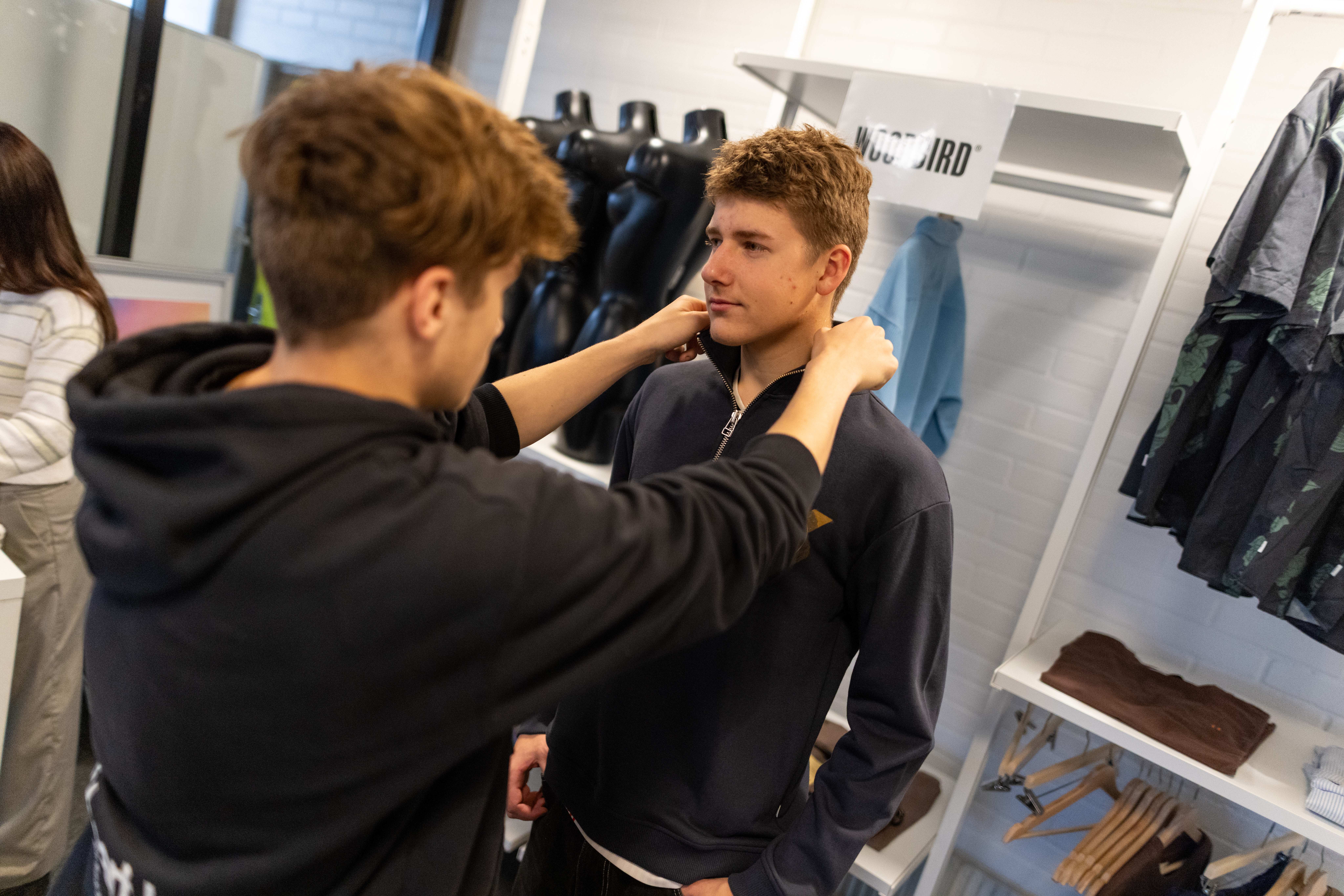 To unge mænd arbejder med tøj i en butik