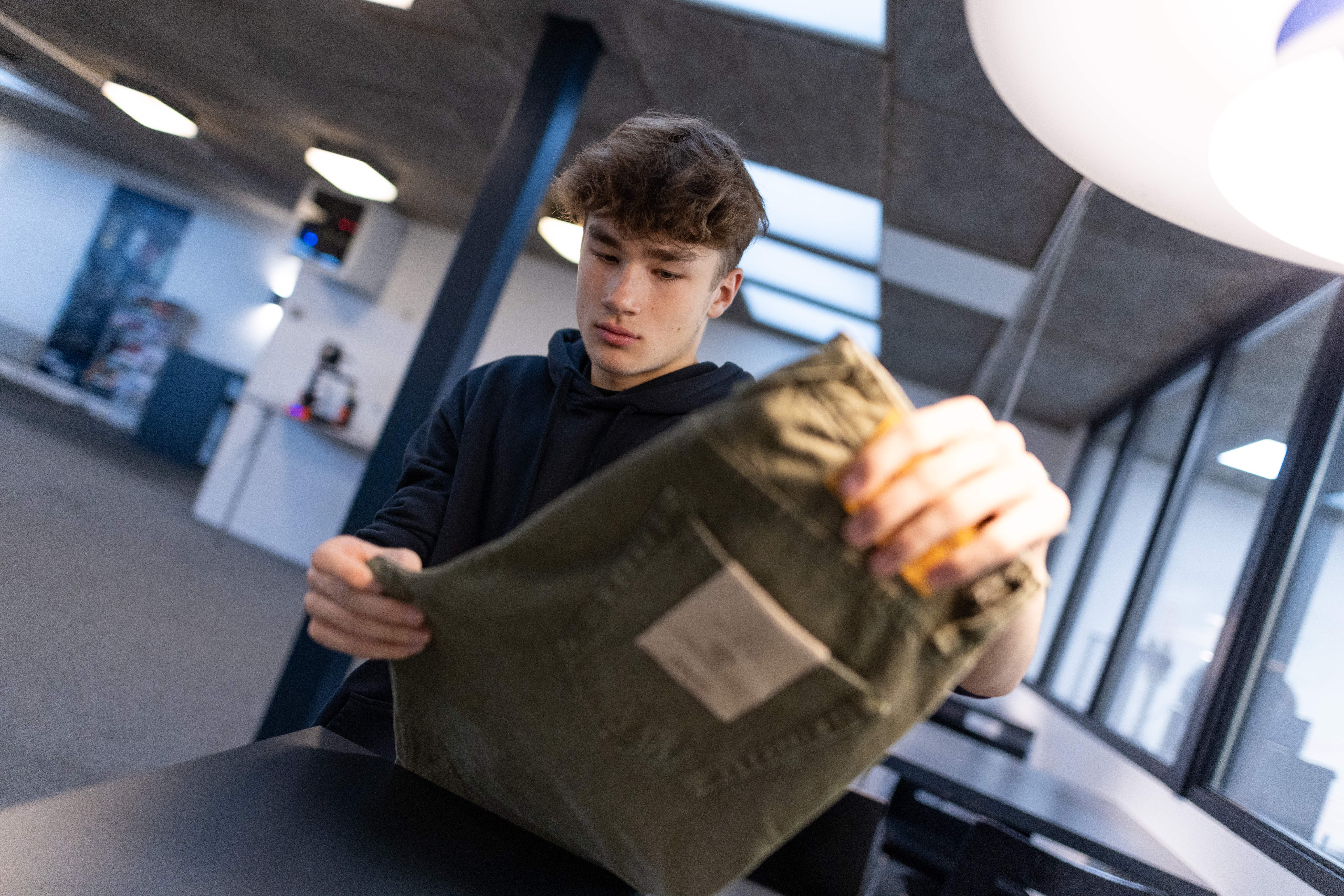 Ung mand holder en taske i en butik