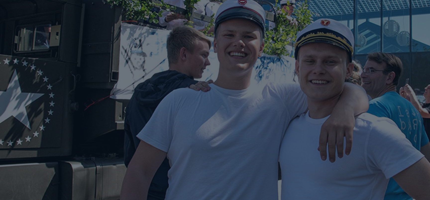 To unge mænd står sammen og smiler udenfor