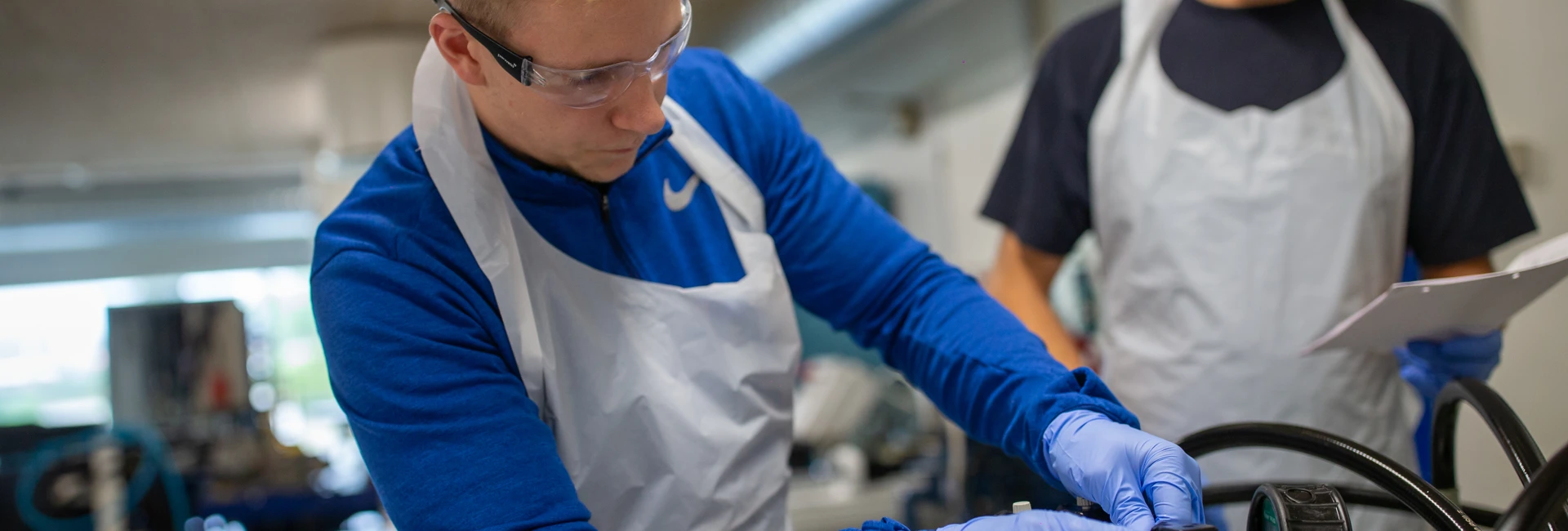 Person i sikkerhedsudstyr arbejder med metal på et værksted