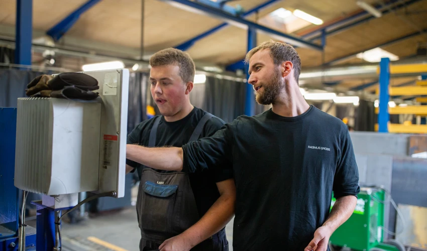 Ung mand arbejder med værktøj i et værksted eller lager